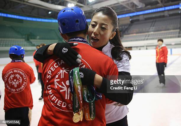 Laureus World Sports Academy member Yang Yang gives a child a medal during a visit to a Laureus Sport For Good Project prior to the Laureus World...