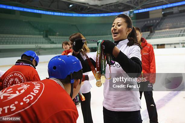 Laureus World Sports Academy member Yang Yang gives a child a medal during a visit to a Laureus Sport For Good Project prior to the Laureus World...