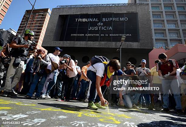 Anti-government students paint graffitis on the street during a protest in front of the Venezuelan Judiciary building in Caracas on February 15,...