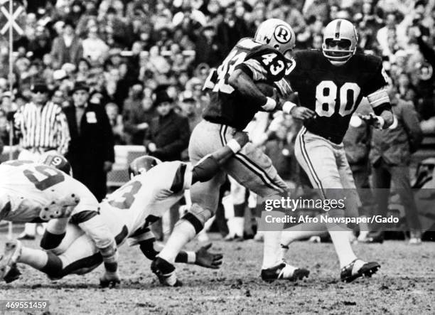 Larry Brown, football player for Washington Redskins, breaking a Carl Lockhart tackle, football player with the Giants, at the Redskins Stadium...