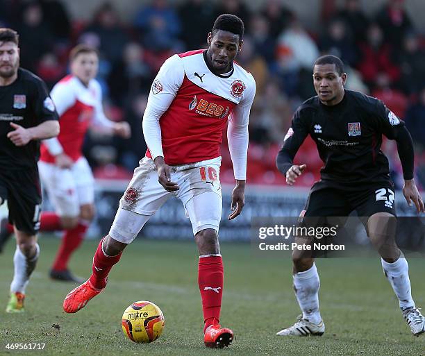 Jamille Matt of Fleetwood Town looks to play the ball watched by Mathias Kouo-Doumbe of Northampton Town during the Sky Bet League Two match between...