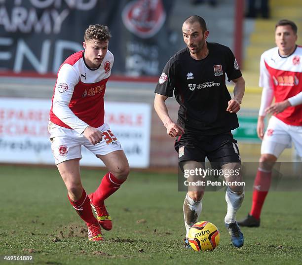 Chris Hackett of Northampton Town looks to play the ball watched by Alex Marrow of Fleetwood Town during the Sky Bet League Two match between...