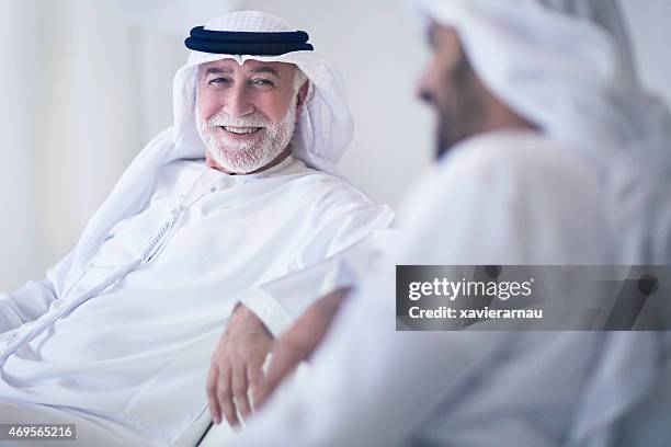 vater und sohn sprechen - emirati enjoy stock-fotos und bilder