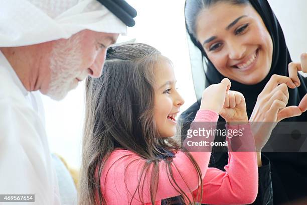arabian family making heart symbols with hands in a cafe - arab family happy stock pictures, royalty-free photos & images