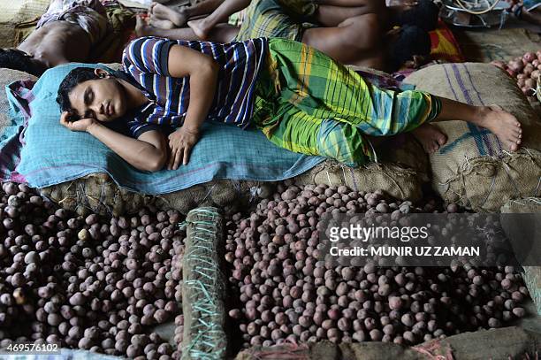 Bangladeshi vendor sleeps at the wholesale central Kawran Bazaar in Dhaka on April 13, 2015 during a strike called by Jamaat-e-Islami to protest...