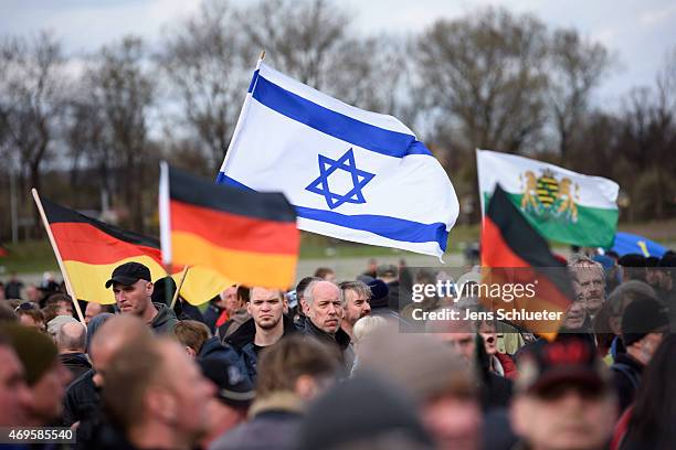 People attend a weekly Pegida demonstration on April 13, 2015 in Dresden, Germany. A large number of supporters and opponents are expected to attend...