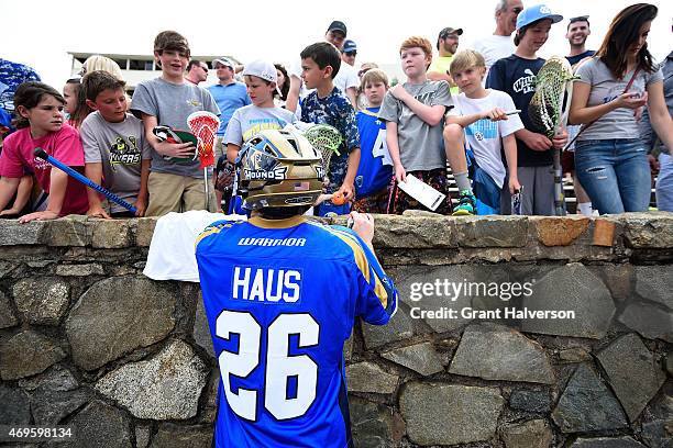 John Haus of the Charlotte Hounds signs autographs for fans after their game against the Rochester Rattlers at American Legion Memorial Stadium on...