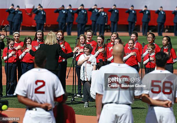 Boston Marathon victim Jane Richard and members of the St. Ann's Children's Choir of Dorchester sing the national anthem before the game. The Boston...