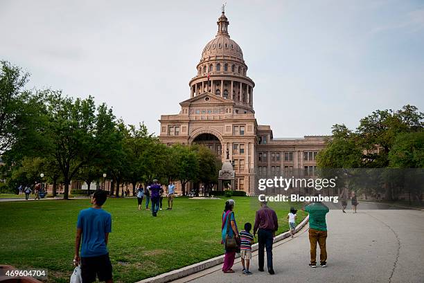 Tourists visit the Texas State Capitol building in Austin, Texas, U.S., on Friday, April 3, 2015. About 900,000 people live in the city of Austin and...