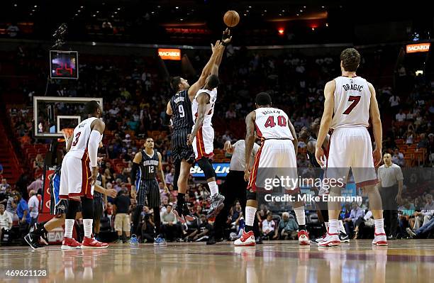 Hassan Whiteside of the Miami Heat and Nikola Vucevic of the Orlando Magic jump ball during a game at American Airlines Arena on April 13, 2015 in...