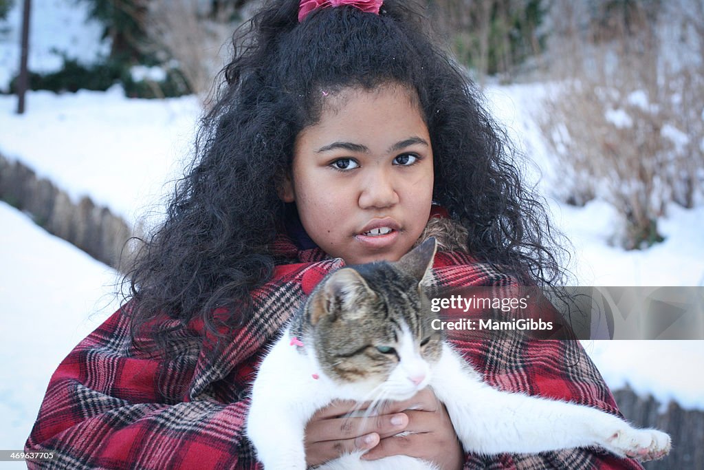 Girl is holding cat at the snow park