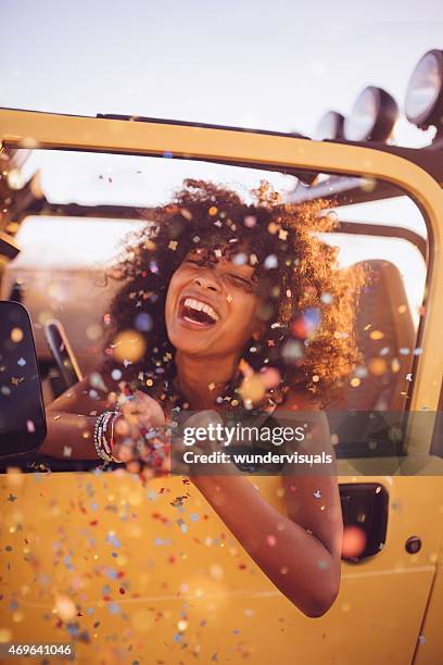 afro femme sur un road trip jeter des confettis - girl laughing photos et images de collection