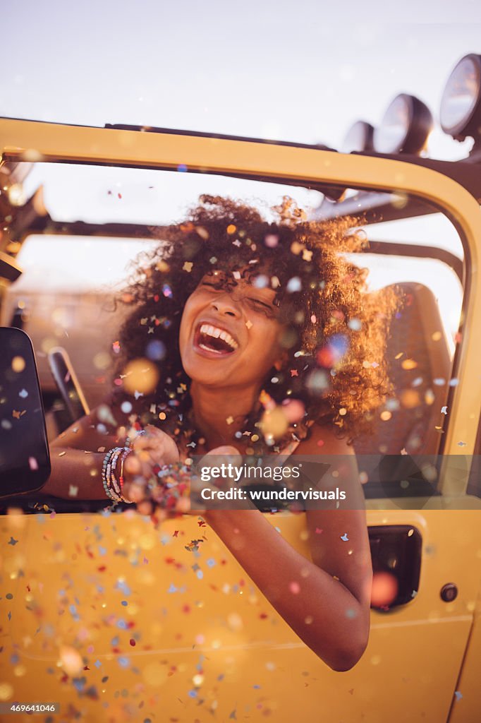 Afro girl on a road trip throwing confetti