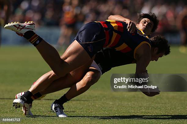 Angus Monfries of the Power tackles Kyle Hartigan of the Crows during the round two AFL NAB Challenge Cup match between the Adelaide Crows and the...