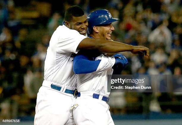 Alex Guerrero of the Los Angeles Dodgers is hugged by Yasiel Puig after Guerrero's game winning walk off RBI single in the 10th inning against the...