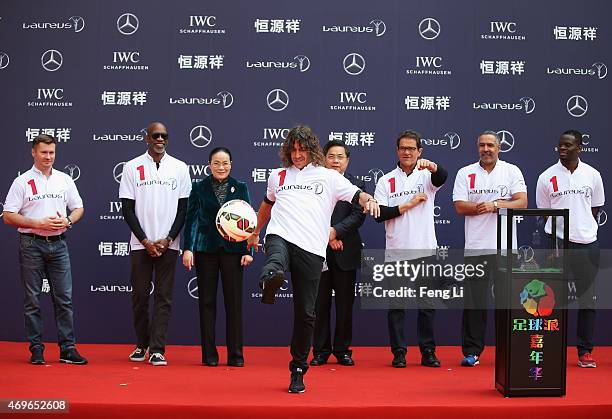 Former Barcelona footballer Carles Puyol of Spain kicks a ball from the stage watched by Laureus World Sports Academy member Alexey Nemov, Laureus...