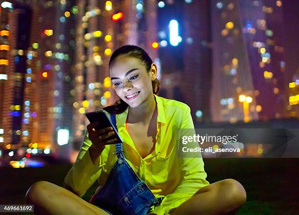 woman texting on the smart phone in dubai marina - dubai marina stock pictures, royalty-free photos & images