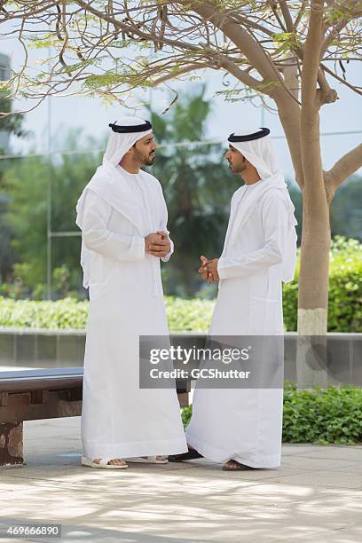 two arab men in conversation - united arab emirates university stock pictures, royalty-free photos & images