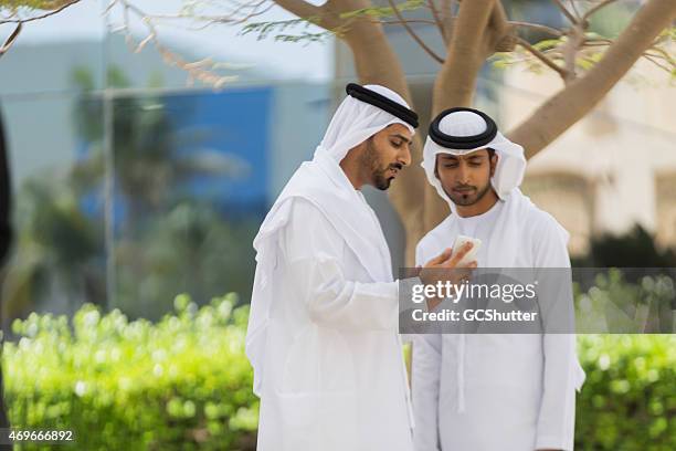 two arab men in conversation - united arab emirates university stock pictures, royalty-free photos & images