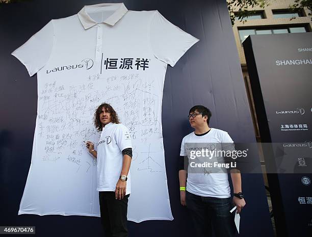 Former Barcelona footballer Carles Puyol of Spain poses with a large Laureus t shirt after becoming a Laureus World Sports Ambassador during a...