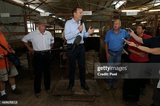 Prime Minister Tony Abbott stands on a wool scale in the shearing shed of graziers Phillip and Di Ridge of "Jandra" as part of a drought tour with...