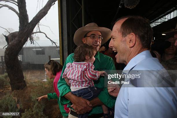 Ben Ritchie admires the rain with his daughter Georgina 1 and the Prime Minister Tony Abbott after he met graziers in the shearing shed at "Jandra"...