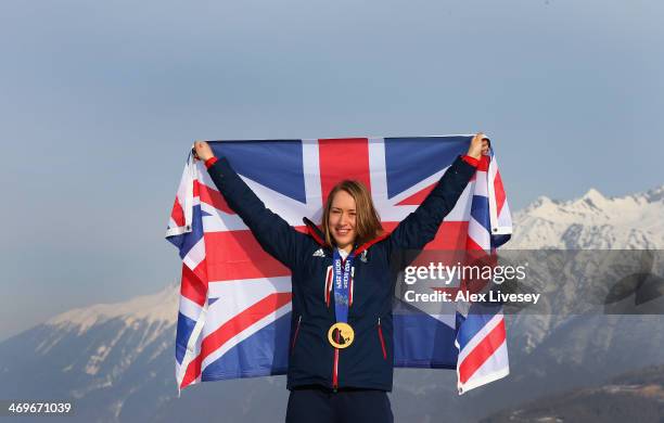 Lizzy Yarnold of Great Britain stands with her gold medal and the Union Jack flag after winning the Women's Skelton as she poses for a portrait at...