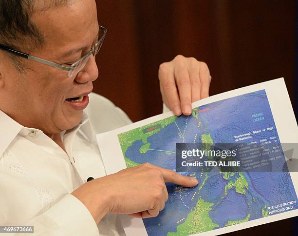 Philippine President Benigno Aquino points to a copy of China's nine-dash line map during an interview with AFP at Malacanang Palace in Manila on...