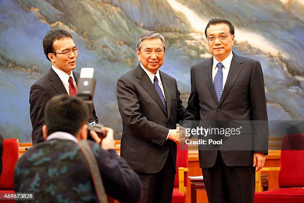 Yohei Kono, head of the Japanese Association for the Promotion of International Trade shakes hands with Chinese Premier Li Keqiang during a meeting...