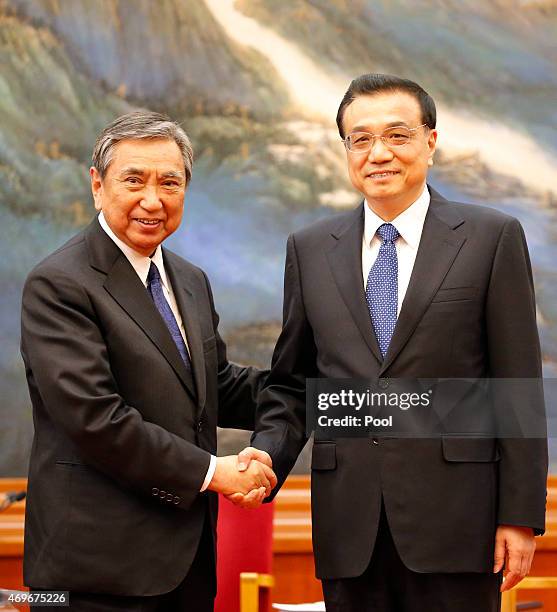 Yohei Kono, head of the Japanese Association for the Promotion of International Trade shakes hands with Chinese Premier Li Keqiang during a meeting...