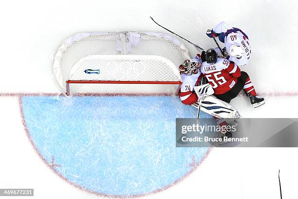 Mathias Lange of Austria collides with teammate Robert Lukas at the net against Ken Andre Olimb of Norway during the Men's Ice Hockey Preliminary...