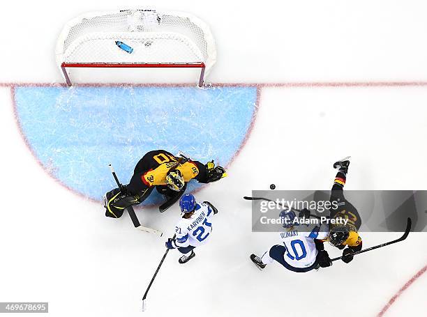 Linda Valimaki of Finland handles the puck against Jennifer Harss and Tanja Eisenschmid of Germany during the Women's Ice Hockey Classification game...