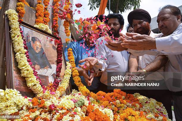 Members of the Shri Guru Ravidass Welfare Society place flowers around a photograph of Indian social reformer, B R Ambedkar to mark his 124th birth...