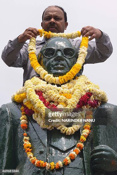 Member of the Shri Guru Ravidass Welfare Society garlands a statue of Indian social reformer, B R Ambedkar to mark his 124th birth anniversay in...