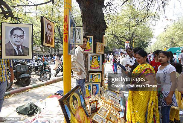 People purchasing portrait and statues of Dr BR Ambedkar after paying tributes on his birth anniversary at Parliament Street on April 14, 2015 in New...