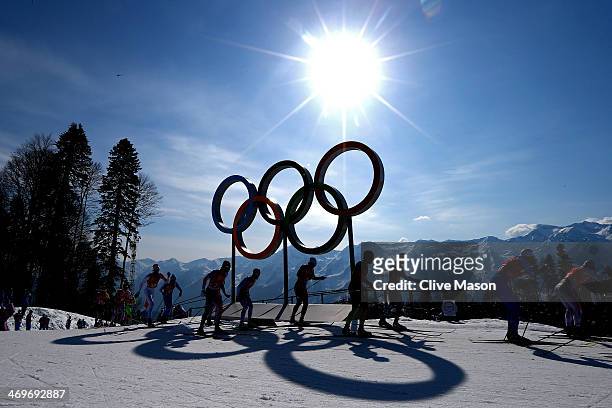Cross country skiers competes past the Olympic Rings on the first leg of the Cross Country Men's 4 x 10 km Relay during day nine of the Sochi 2014...
