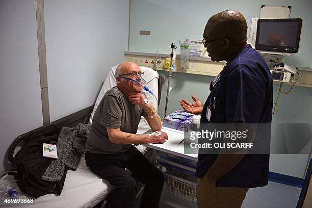 Consultant doctor speaks with a patient wearing breathing apparatus in the Accident and Emergency department of the 'Royal Albert Edward Infirmary'...