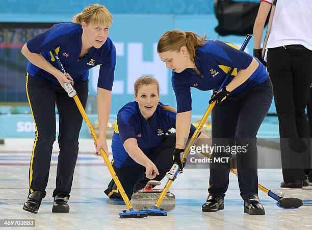 Sweden's Maria Prytz, center, releases a stone as her teammates Christina Bertrup, left, and Maria Wennerstroem start to sweep during the game...