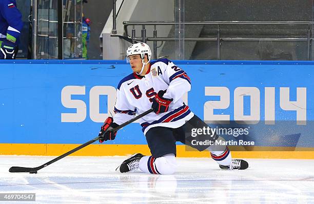 Dustin Brown of the United States handles the puck in the third period against Slovenia during the Men's Ice Hockey Preliminary Round Group A game on...