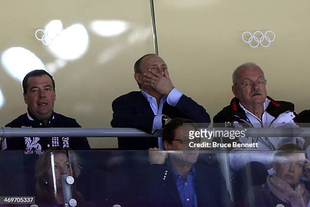 Russian President Vladimir Putin and Prime Minister Dmitry Medvedev watch the Men's Ice Hockey Preliminary Round Group A game between Russia and...