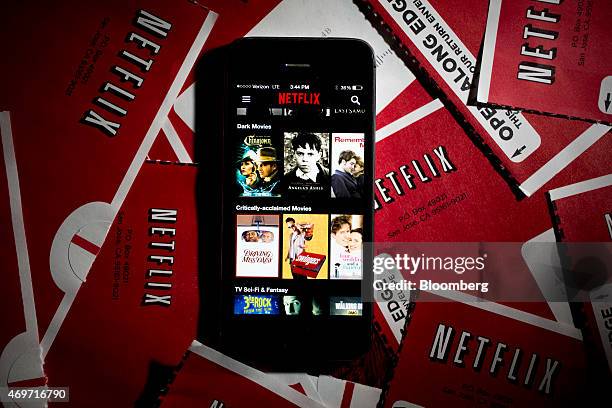 The Netflix Inc. Application is displayed on an Apple Inc. IPhone 5s surrounded by DVD mailers in this arranged photograph in Washington, D.C., U.S.,...