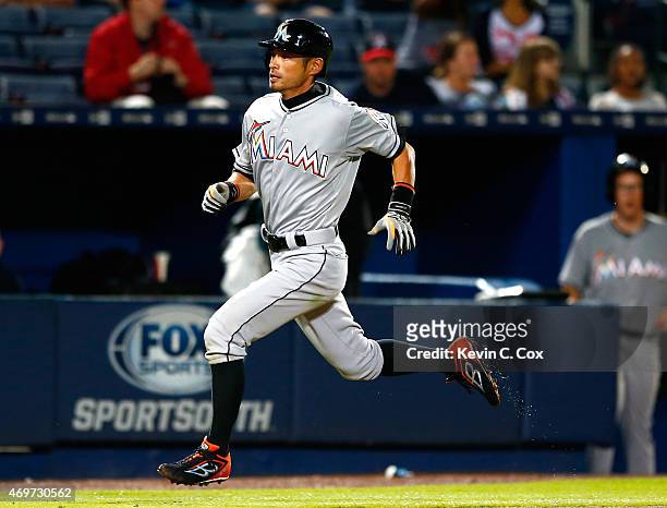 Ichiro Suzuki of the Miami Marlins scores on a double hit by Giancarlo Stanton in the eighth inning against the Atlanta Braves at Turner Field on...