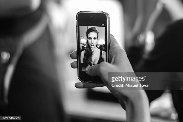 Model take a self-portrait with a phone at the backstage during day one of Mercedes-Benz Fashion Week Mexico Fall/Winter 2015 at Campo Marte on April...