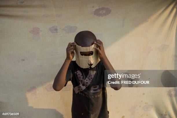 Boy puts on a mask in the Mpoko refugee camp in Bangui, Central African Republic, on February 16, 2014. Troops from several EU countries will begin...