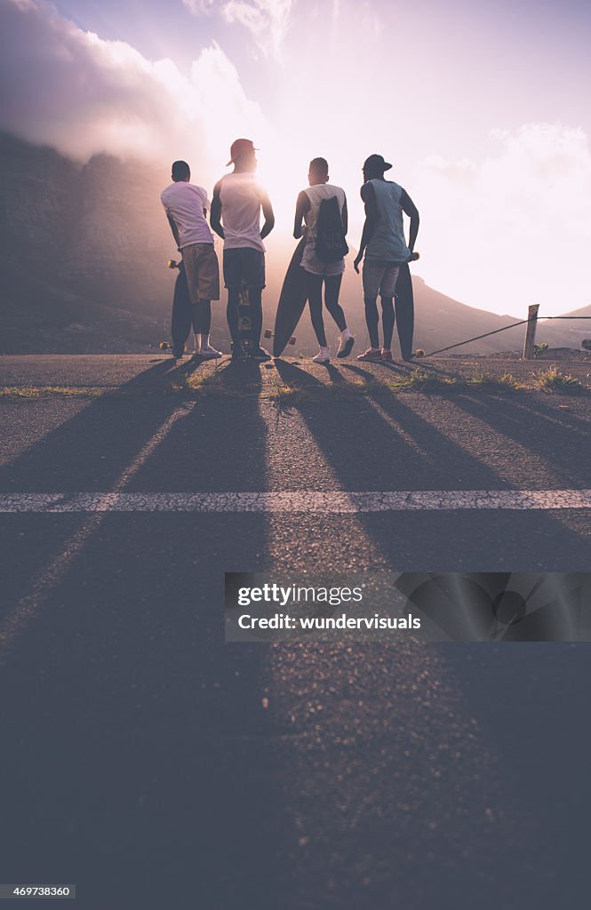 Group of teenage skater friends at sunset