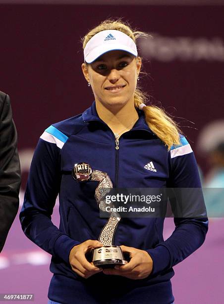 Angelique Kerber of Germany poses with her second place trophy after losing her WTA Qatar Total Open final match against Simona Halep of Romania on...