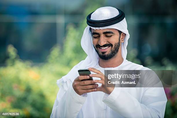 middle eastern businessman using mobile phone - arab and mobile stock pictures, royalty-free photos & images