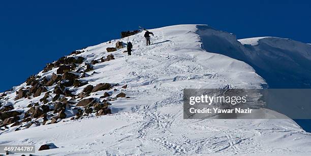 French sportsmen along with their local guide ascend the mountain before descending the snow slopes after the winter sports Alpine and Snow-boarding...