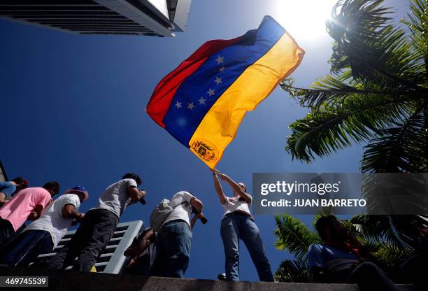 An anti-government student waves a Venezuelan flag during a protest rally in Caracas on February 16, 2014. Supporters and opponents of Venezuela's...