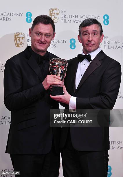 British writer, producer and actor Steve Coogan and British writer Jeff Pope pose with the award for an adapted screenplay for "Philomena" at the...